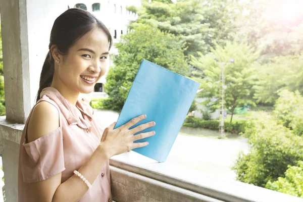 The asian girl reads a blue book — Stock Photo, Image