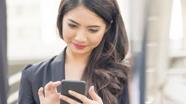 Retrato de uma bela mulher de pessoas de negócios vestida estritamente com os ternos usar telefone inteligente . — Fotografia de Stock