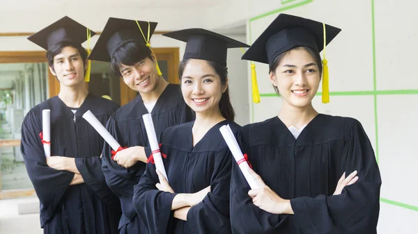 The people students man and woman with black graduation gowns ho — Stock Photo, Image