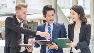 Takım iş insanlar akıllı erkek ve kadın açık yaya acele saat dosya mevcut kağıt çalışma ile konuşmak