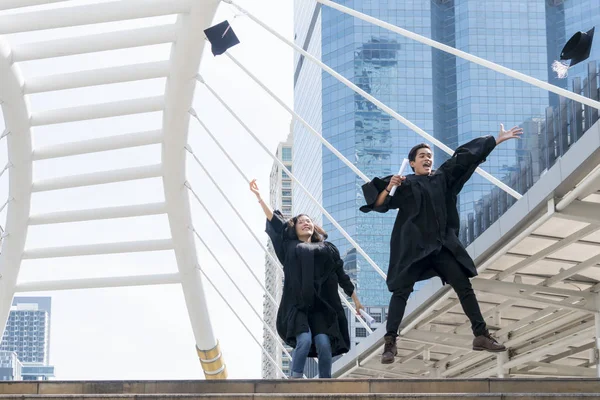 Glada graduate tonåring människor hoppa med den examen klänningar i — Stockfoto
