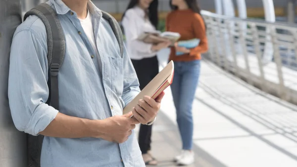 Energetic optimistic teen man with stationary and book stand fro — Stock Photo, Image