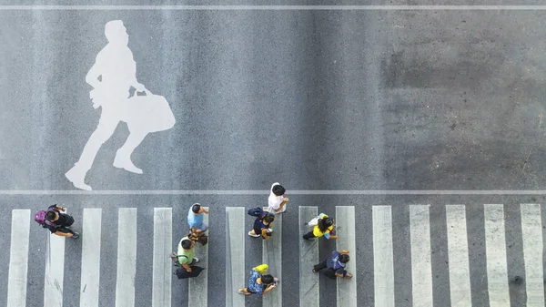 Ovanifrån av vit symbol med affärsman köra med portföljen på gågatan vägskäl och folk går cross street — Stockfoto