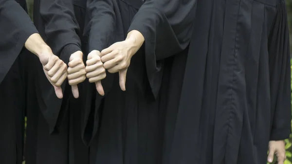 Personnes avec des robes de graduation noires fouetter vers le bas — Photo