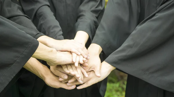 Personas con vestidos negros se unen de la mano en la agrupación . —  Fotos de Stock