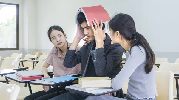 Люди студент читать книги и держать над головой и сидеть лекционные стулья — стоковое фото