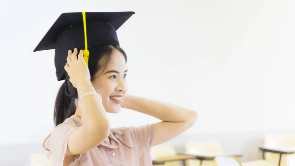 Девушка студентка в шляпе выпускника в классе — стоковое фото