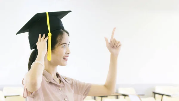 Flicka student med examen hatt i klassrummet — Stockfoto