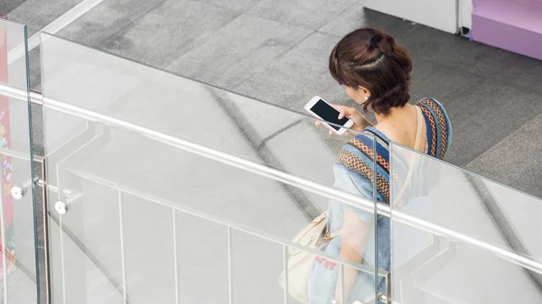 Retrato de las personas de espalda mujer vestida tela de moda utiliza el teléfono inteligente . —  Fotos de Stock