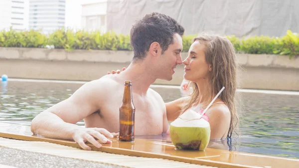 Pareja de hombre y chica sexy en bikini ropa interior de moda dulce amor en la piscina con alcohol de bebida y jugo de coco — Foto de Stock