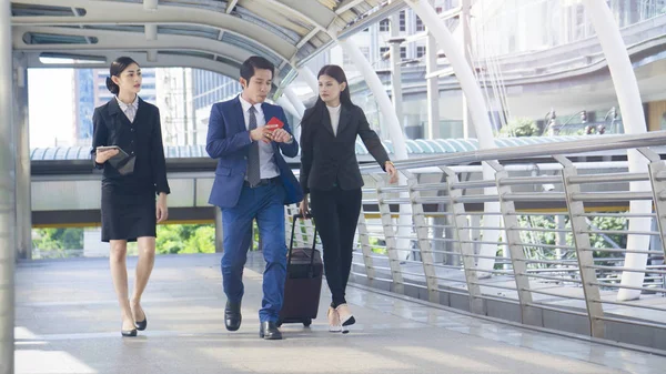 Group smart business people of man and woman walk together in rush hour in feeling stress  with tablet smart phone device and luggage at the outdoor pedestrian walkway space in the morning. — Stock Photo, Image
