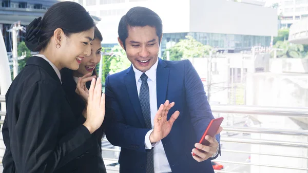 Group smart business people of man and woman talk together and video call yourself in feeling happy with tablet smart phone device at the outdoor pedestrian walkway space in the morning. — Stock Photo, Image