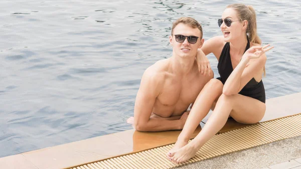 Pareja joven relajándose en la piscina — Foto de Stock