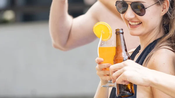 Donna con occhiali da sole in costume da bagno tiene il bicchiere di succo d'arancia cocktail — Foto Stock