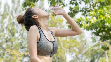 Asya sevimli spor sağlıklı ve uygun firma genç kız içki su taraftan plastik şişe açık bahçe yaz sıcak günde ince