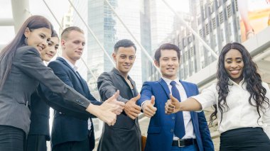 İş adamlarından oluşan bir ekip zeki bir adam ve bir kadın yaya geçidinde el ele tutuşuyorlar..