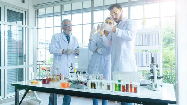 Gruppe Von Menschen Wissenschaftler Mit Einem Schlauch Mit Flüssiger Substanz — Stockfoto