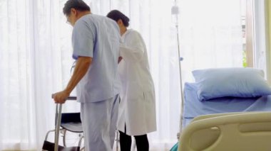 Kuaför Asyalı kadın moda gelinliği stüdyosundaki en iyi beyaz gelinliği ayarlar ve seçer. Giyim sektöründe beyaz düğünün arka planında.