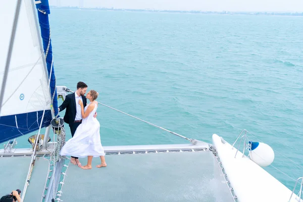 luxury relaxing couple traveler in nice dress and suite stand at part of cruise yacht with background of water sea and white sky. Concept business travel.