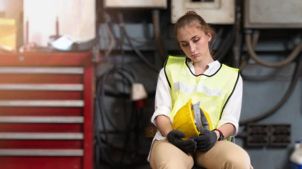 Fabrika işçisi sandalyede oturuyor ve stres altında fabrika atölyesinde başarısız oluyor..