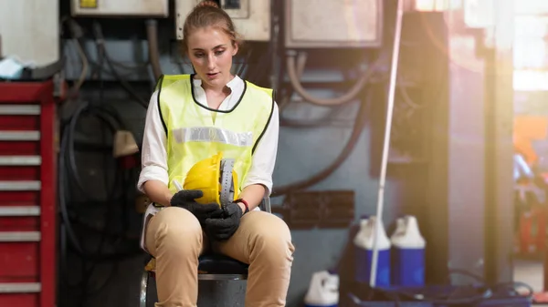 Fabrika işçisi sandalyede oturuyor ve stres altında fabrika atölyesinde başarısız oluyor..