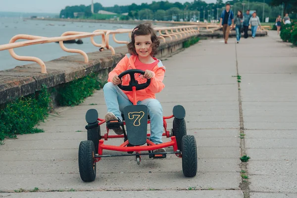 Küçük kız üzerinde pedal karting sürme.