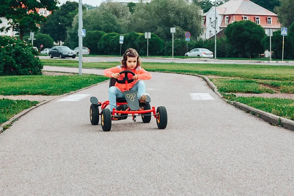Küçük kız üzerinde pedal karting sürme.