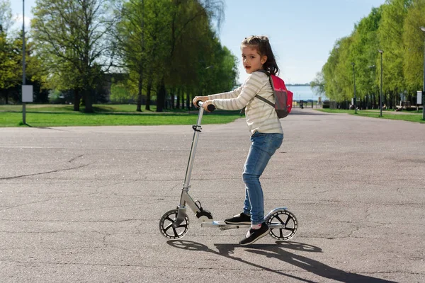 Uma criança está montando uma scooter . — Fotografia de Stock