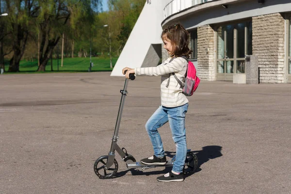 Bir çocuk bir scooter sürme.