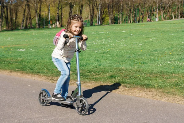 Bir çocuk bir scooter sürme.