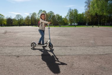 Bir çocuk bir scooter sürme.