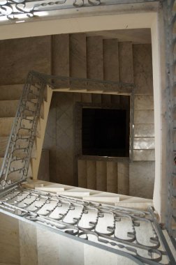 Merdivenlerden aşağı bakıyor