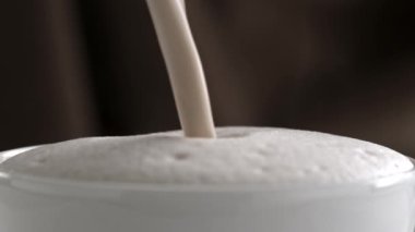 Sütlü kapuçino Kupası ağır çekimde dökme