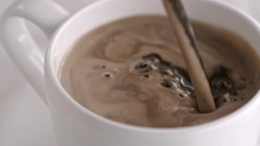 Sütlü kapuçino Kupası ağır çekimde dökme