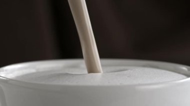 Sütlü kapuçino Kupası ağır çekimde dökme