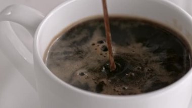 Sütlü kapuçino Kupası ağır çekimde dökme