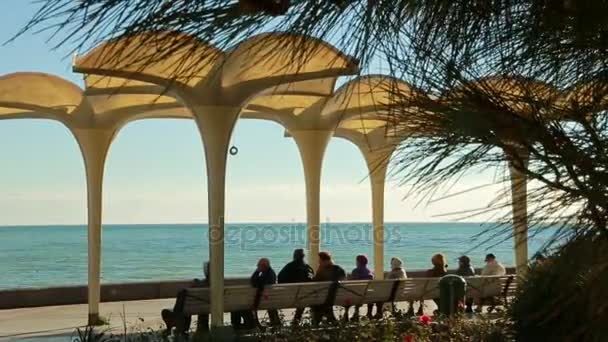 Menschen gehen entlang der Strandpromenade — Stockvideo