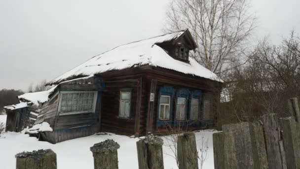Het oude, vervallen dorpshuis met buitenramen in de winter. — Stockvideo