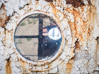 Terk edilmiş eski bir gemi penceresi.