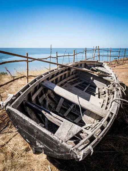 Старий порожній старовинний рибальський човен стоїть на пляжі Стокове Фото