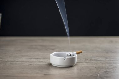 Kül tablası içinde yanan bir sigara