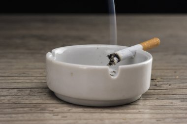 Kül tablası içinde yanan bir sigara