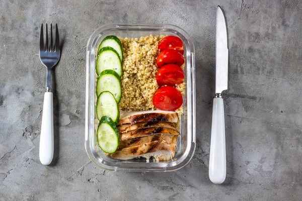 Healthy meal prep containers with quinoa, chicken and arugula