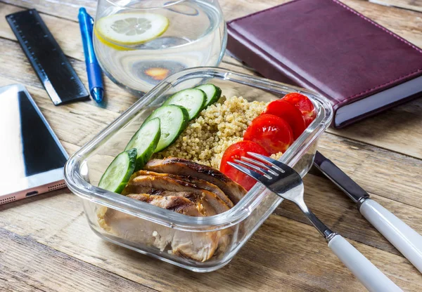 Healthy meal prep containers with quinoa, chicken and arugula