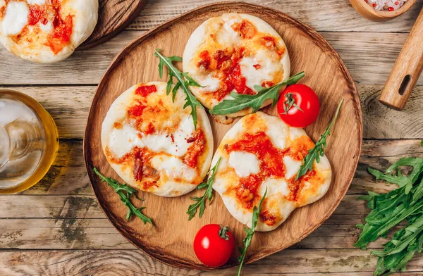 Pizzete. Home baked mini pizzas bolognese. Tomato sauce ,mozzarella cheese and minced meat. Rustic wooden table. Top view. Stay at home concept