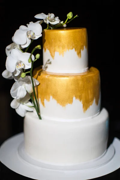 Многоуровневый свадебный торт с белыми орхидеями — стоковое фото