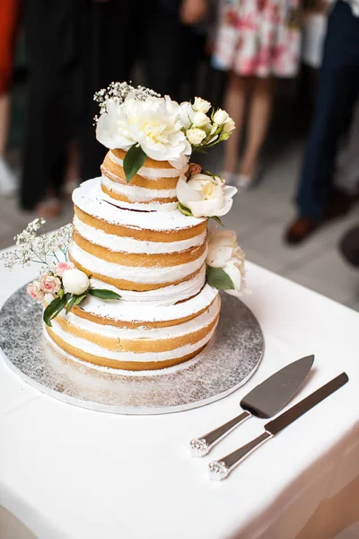 Multi level wedding cake with flowers on the table