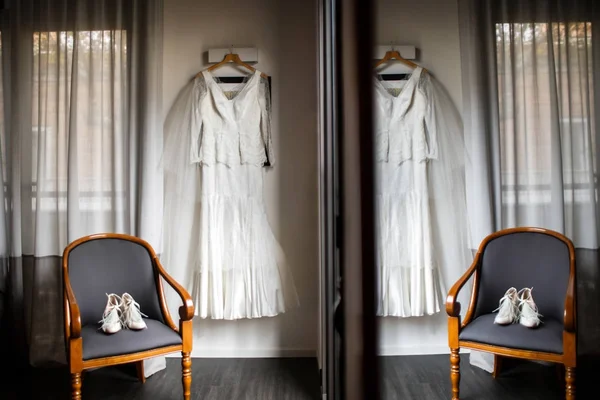 Hochzeitskleid und Schuhe auf einem Stuhl in Reflexion — Stockfoto
