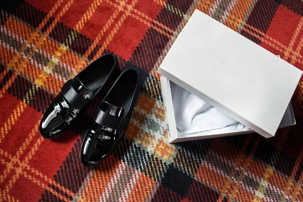 Düğün siyah ayakkabıları ve renkli yerdeki beyaz kutu — Stok fotoğraf