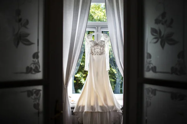 Robe de mariée suspendue à la fenêtre dans la chambre — Photo